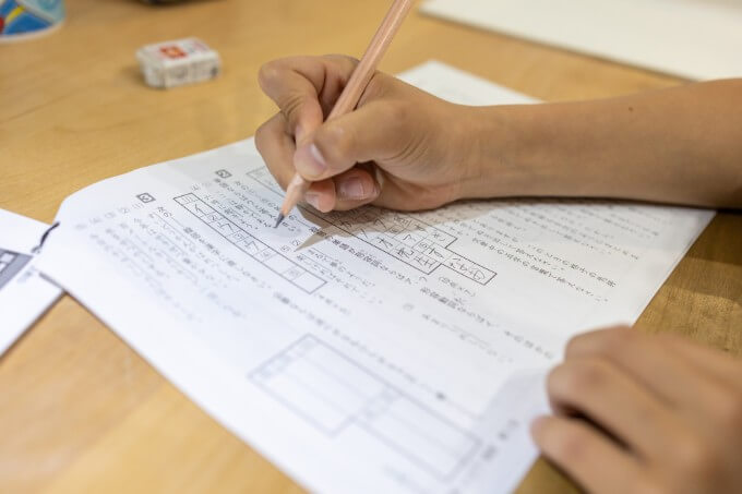 答案用紙に記入する児童の手