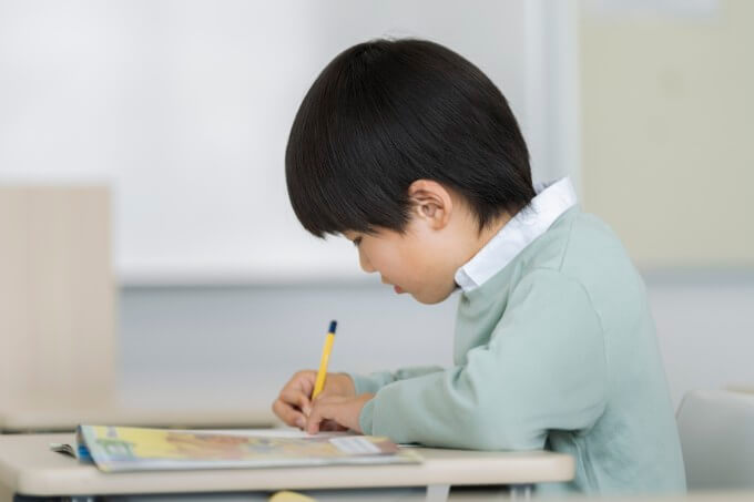 机で勉強する男子児童